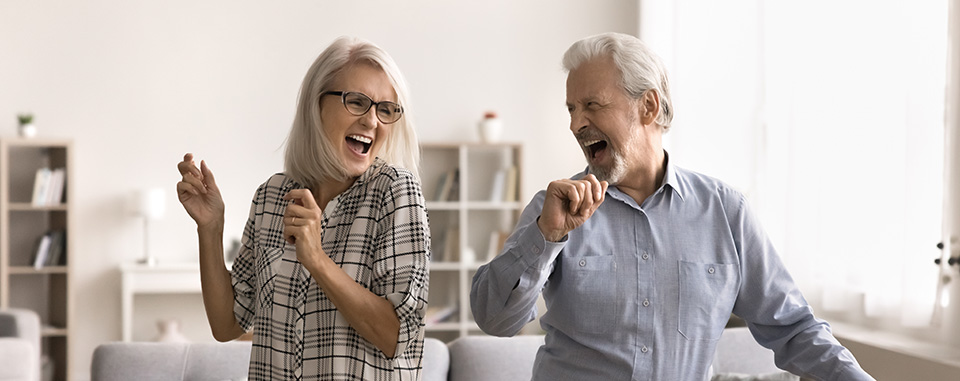 Starsze małżeństwo radośnie tańczy w pokoju